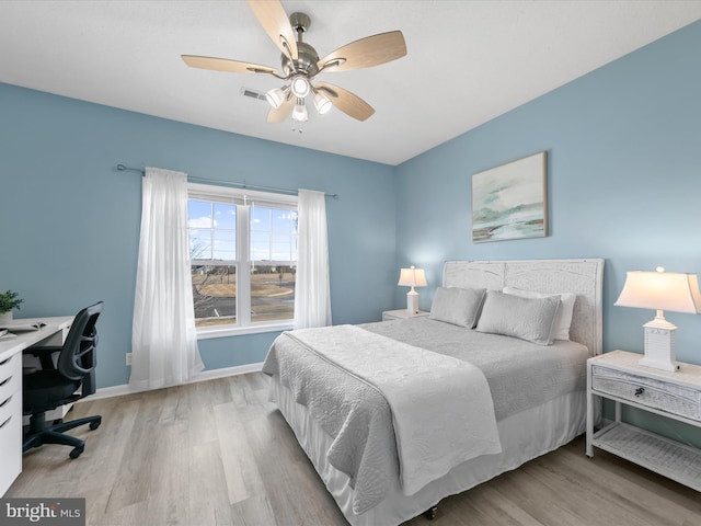 bedroom featuring visible vents, light wood finished floors, a ceiling fan, and baseboards