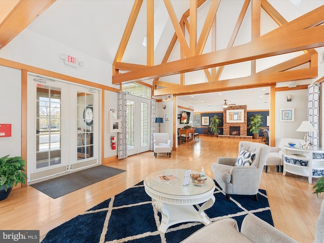 living area featuring light wood finished floors, high vaulted ceiling, french doors, and beamed ceiling