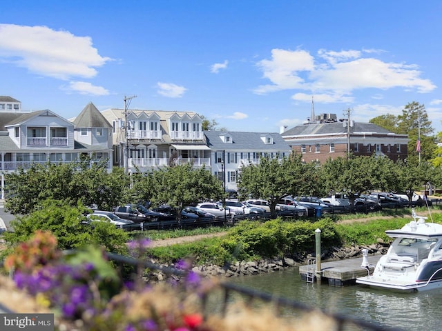 surrounding community with uncovered parking, a residential view, a water view, and a boat dock