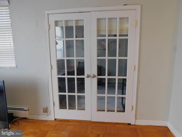 interior details with parquet flooring, french doors, and a baseboard heating unit