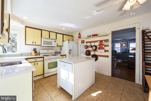 kitchen featuring white appliances, crown molding, a sink, and light tile patterned flooring