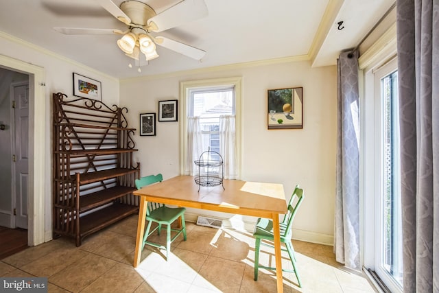 dining space with ornamental molding, light tile patterned flooring, baseboards, and a ceiling fan