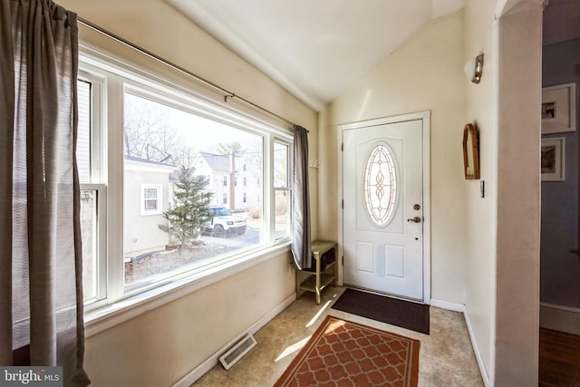 foyer entrance featuring visible vents, vaulted ceiling, and baseboards