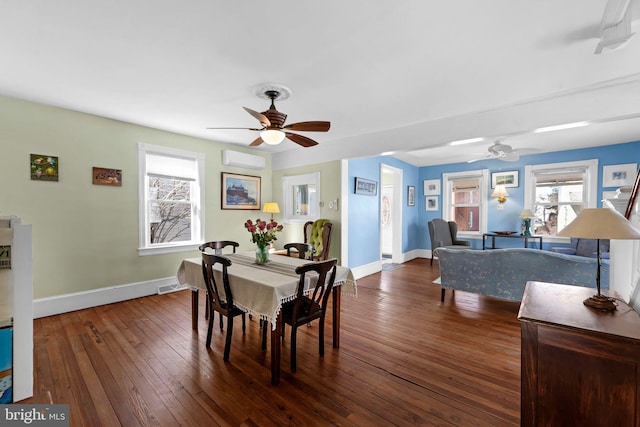 dining space featuring ceiling fan, a wall mounted air conditioner, wood-type flooring, and baseboards