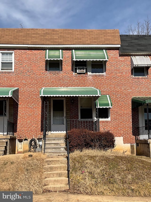 view of property with entry steps and brick siding