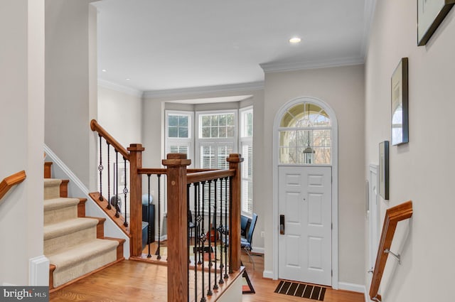 entryway featuring baseboards, stairs, crown molding, light wood-type flooring, and recessed lighting