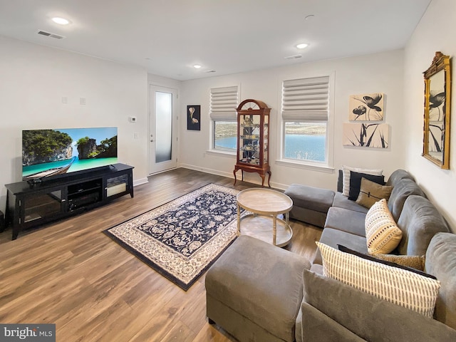 living area featuring recessed lighting, visible vents, baseboards, and wood finished floors