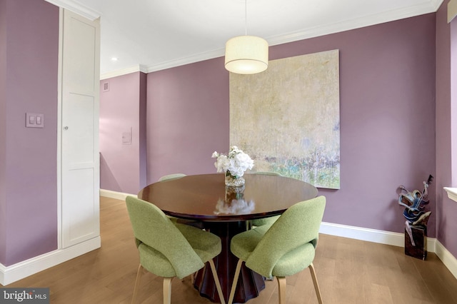 dining space featuring crown molding and wood-type flooring