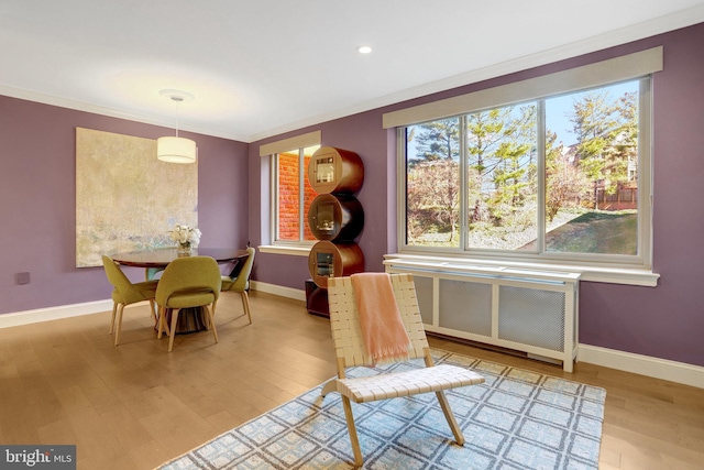 dining space with ornamental molding and hardwood / wood-style floors