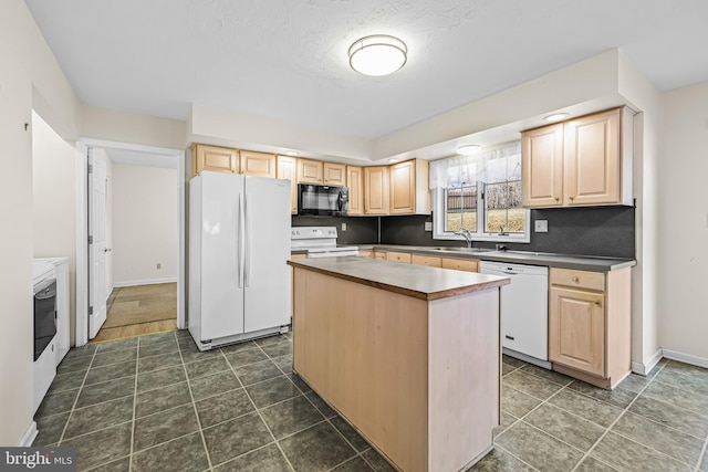 kitchen featuring white appliances, sink, a center island, light brown cabinets, and dark tile patterned floors