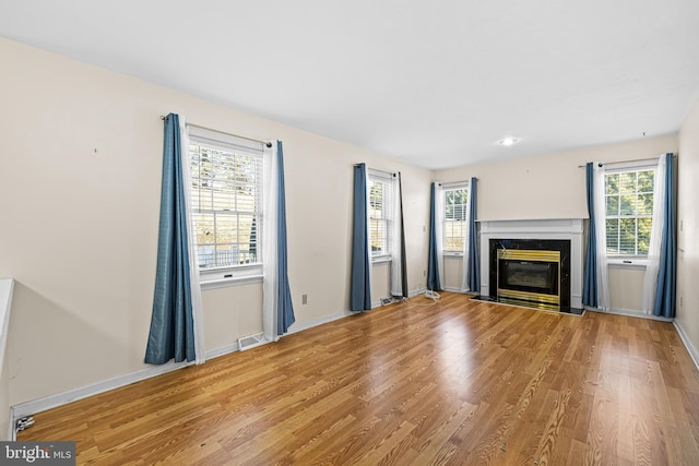 unfurnished living room with light hardwood / wood-style floors and a high end fireplace