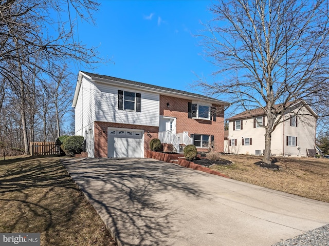 raised ranch with a front lawn and a garage