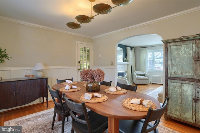 dining room featuring ornamental molding, light hardwood / wood-style floors, and radiator heating unit