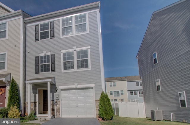 view of front of home featuring central AC unit and a garage