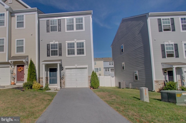 townhome / multi-family property featuring central air condition unit, a front yard, and a garage