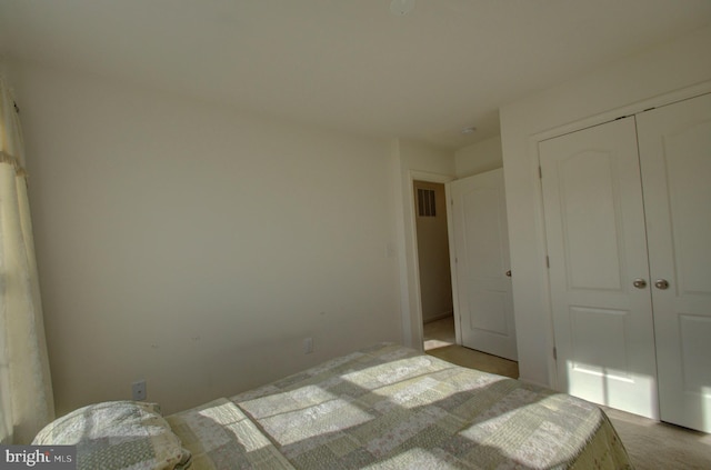 unfurnished bedroom with a closet and light colored carpet