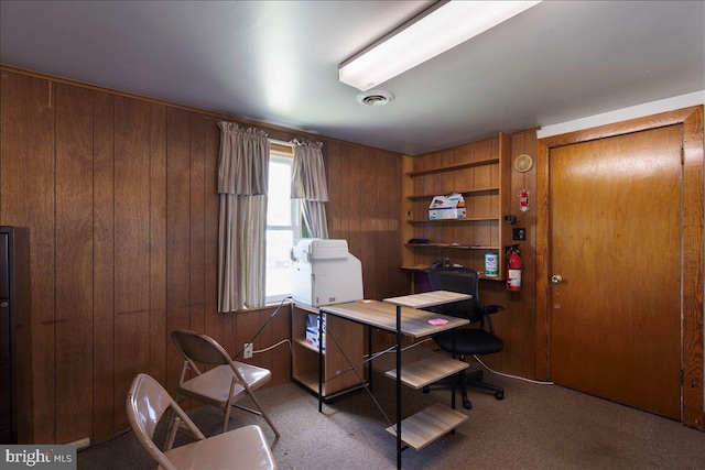 home office with carpet flooring and wooden walls