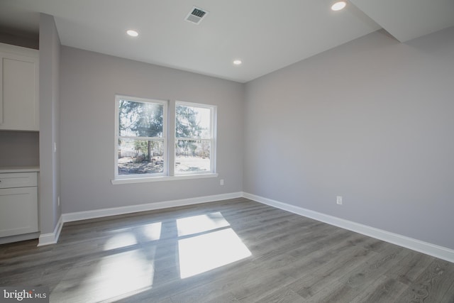 unfurnished dining area featuring recessed lighting, wood finished floors, visible vents, and baseboards