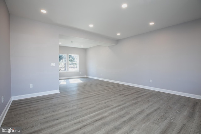 spare room with recessed lighting, wood finished floors, and baseboards