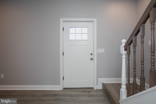 entryway with stairs, wood finished floors, and baseboards