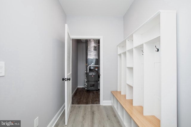 mudroom featuring heating unit, light wood-style flooring, and baseboards