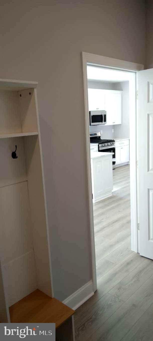 mudroom featuring light wood-style flooring and baseboards