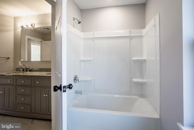 bathroom with marble finish floor, shower / bath combination, and vanity