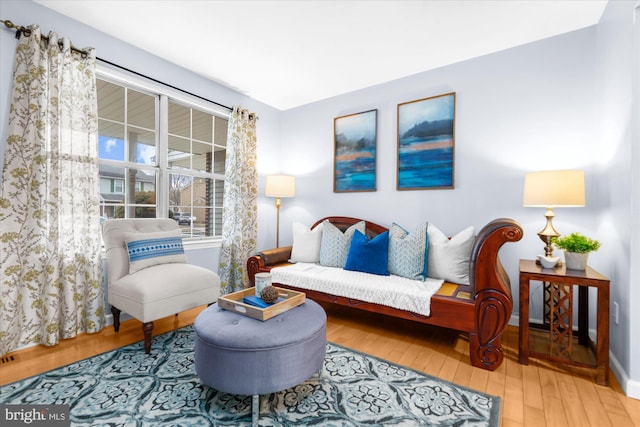 living area with baseboards and wood finished floors