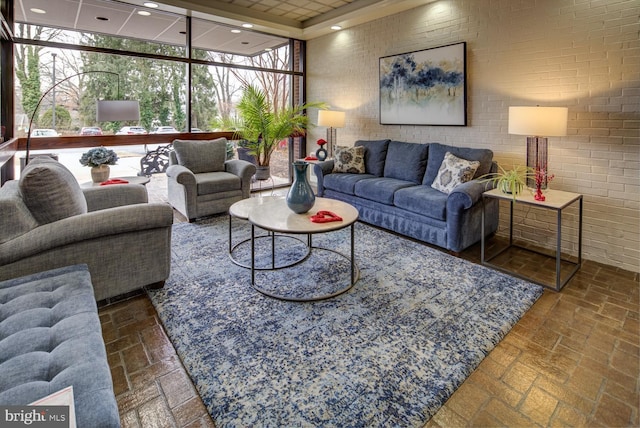 living room featuring expansive windows and brick wall