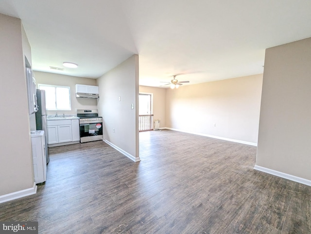 kitchen with stainless steel electric stove, washer / clothes dryer, white cabinetry, sink, and dark wood-type flooring