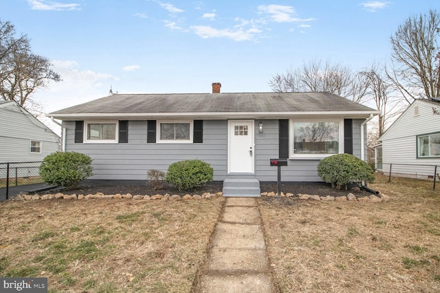 view of front of property featuring a front lawn, a chimney, and fence