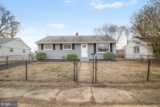 view of front of home with a fenced front yard, a gate, and a front lawn