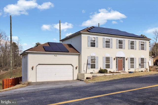 view of front of home featuring solar panels and a garage