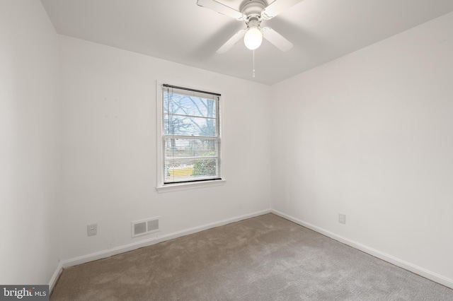 spare room with a ceiling fan, baseboards, visible vents, and carpet flooring