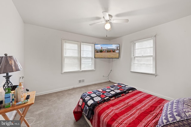 carpeted bedroom with baseboards, visible vents, and a ceiling fan