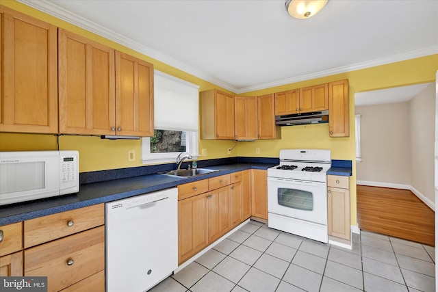 kitchen featuring white appliances, light tile patterned floors, dark countertops, under cabinet range hood, and a sink