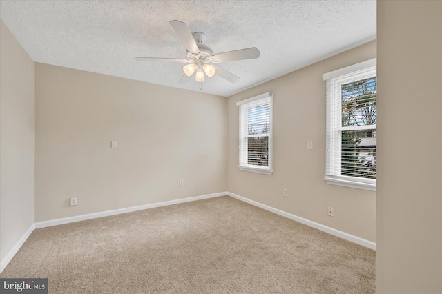 unfurnished room with carpet floors, baseboards, and a ceiling fan