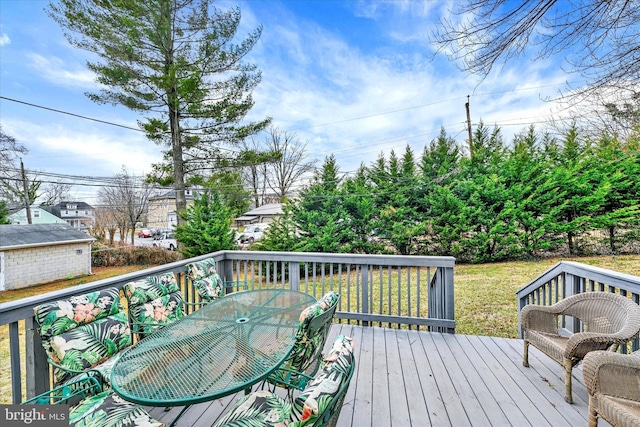 wooden deck featuring outdoor dining area and a yard