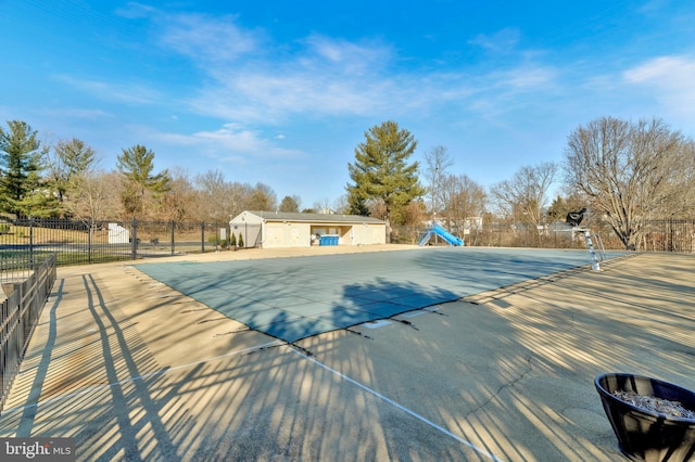 view of swimming pool with a fenced in pool, a water slide, fence, and a patio