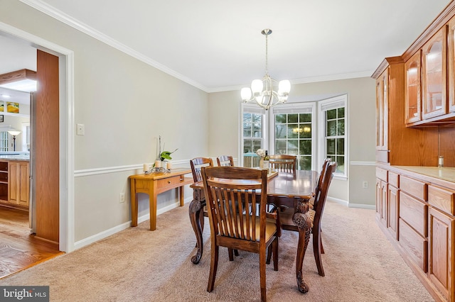 dining area featuring light carpet, ornamental molding, baseboards, and a notable chandelier