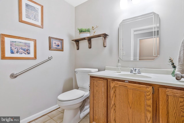 bathroom featuring baseboards, vanity, toilet, and tile patterned floors