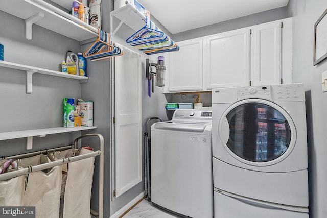 washroom with marble finish floor, separate washer and dryer, and cabinet space