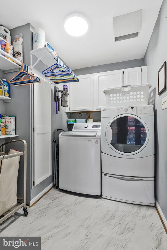 laundry room featuring marble finish floor, cabinet space, independent washer and dryer, and baseboards