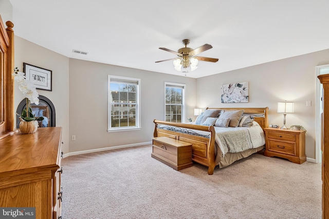 bedroom featuring light carpet, visible vents, baseboards, and ceiling fan