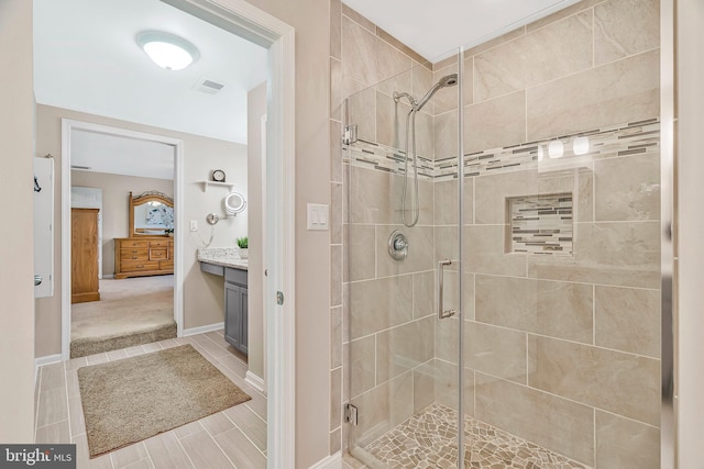 bathroom with a stall shower, baseboards, visible vents, and vanity