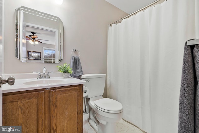 bathroom with tile patterned flooring, vanity, toilet, and a ceiling fan