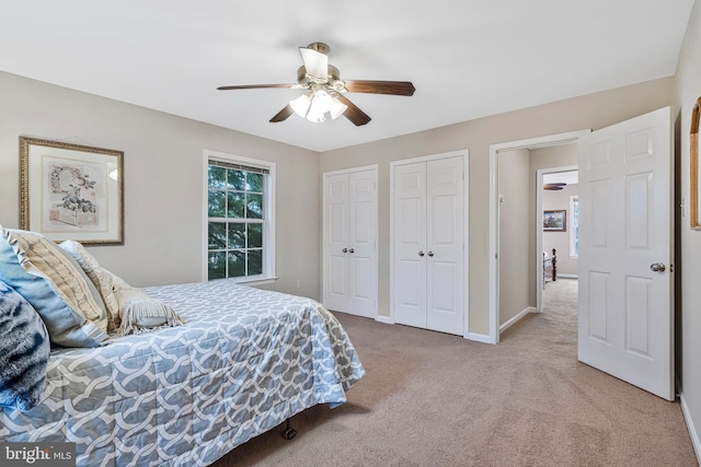 bedroom with multiple closets, carpet, baseboards, and a ceiling fan