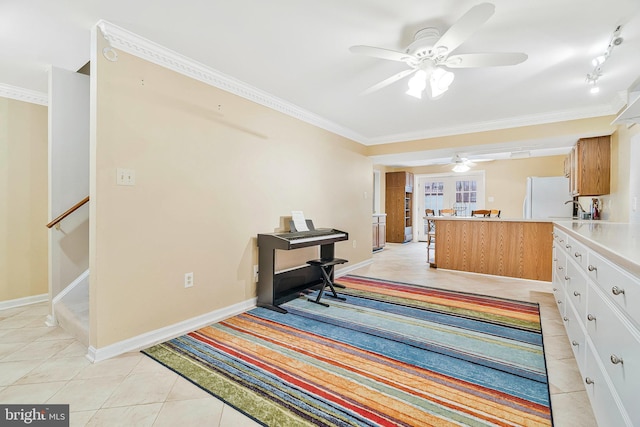 kitchen featuring light tile patterned floors, ornamental molding, and freestanding refrigerator