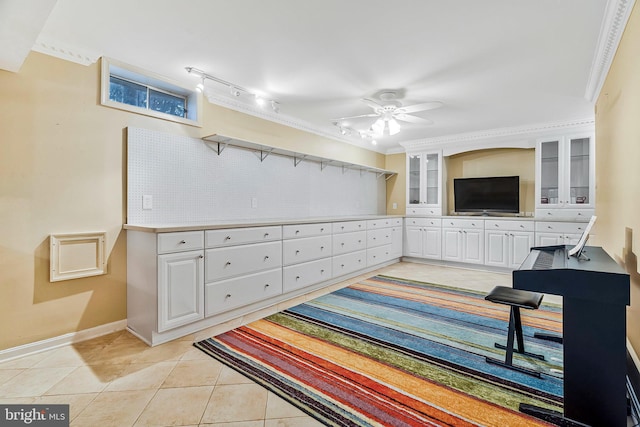 interior space featuring ornamental molding, ceiling fan, baseboards, and light tile patterned floors