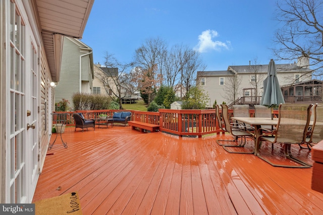 wooden deck with a trampoline and outdoor dining space